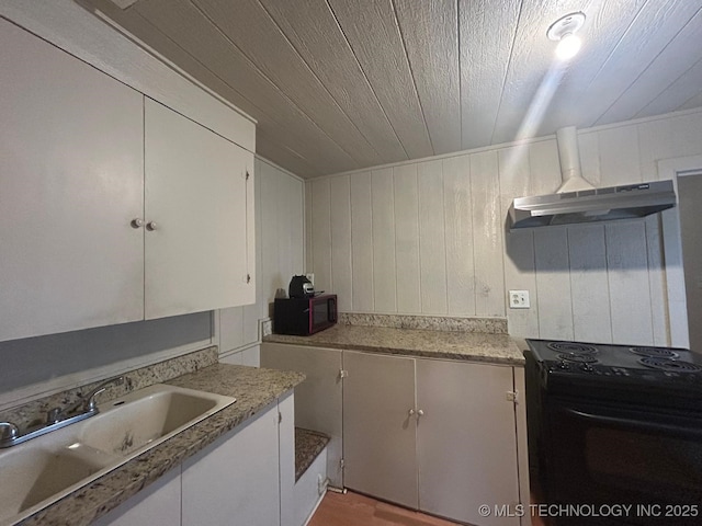 kitchen featuring wooden ceiling, under cabinet range hood, a sink, white cabinets, and black appliances