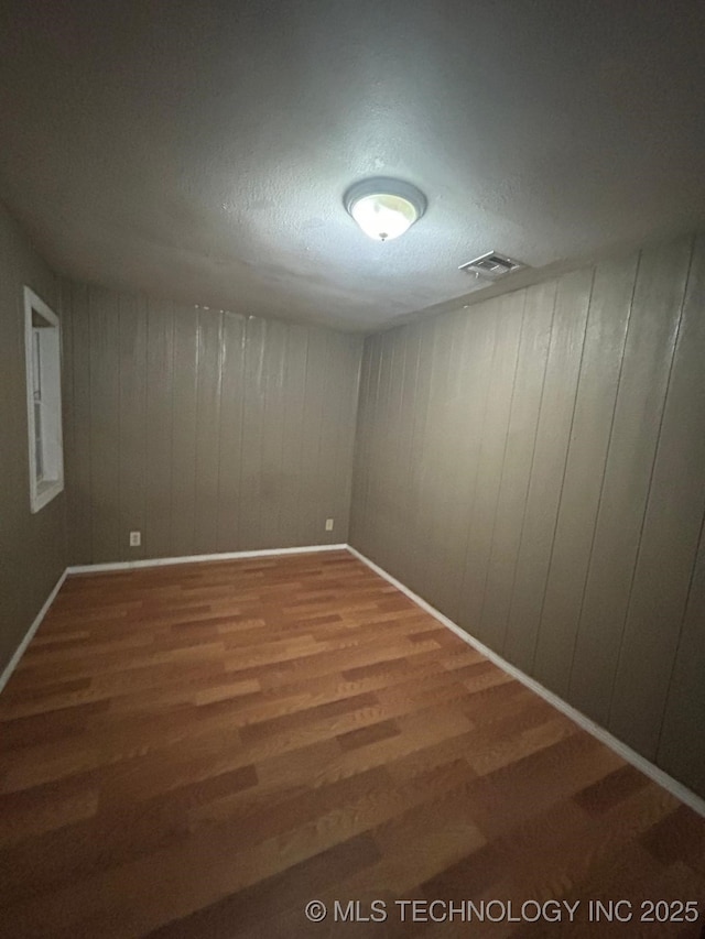 unfurnished room featuring visible vents and wood finished floors