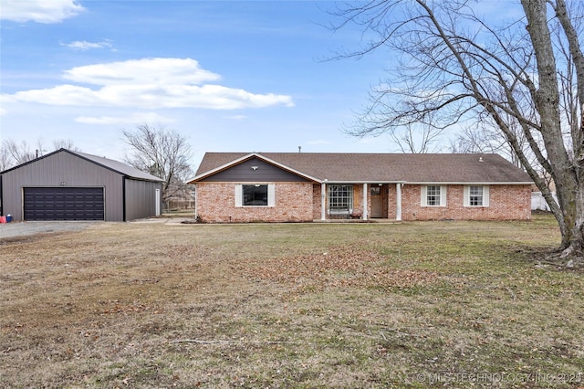 ranch-style home with brick siding, a front lawn, a detached garage, and an outdoor structure