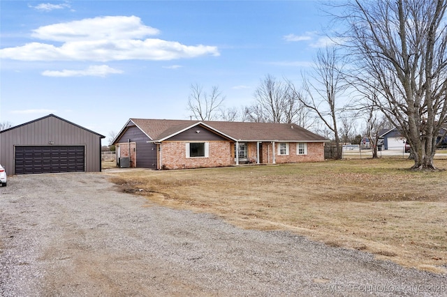 view of front facade with a garage, fence, an outbuilding, and brick siding