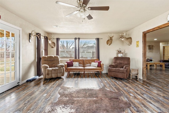 living room with visible vents, a ceiling fan, a textured ceiling, wood finished floors, and baseboards