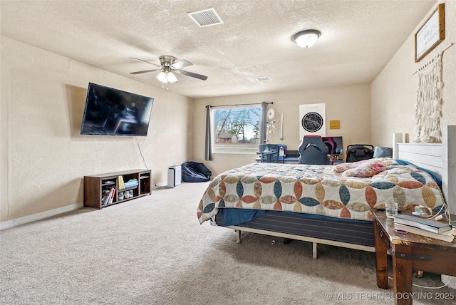 carpeted bedroom featuring baseboards, ceiling fan, visible vents, and a textured ceiling