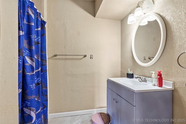 bathroom with tile patterned flooring, a textured wall, vanity, and a shower with shower curtain