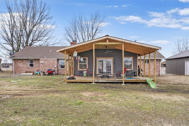 rear view of house featuring brick siding, a ceiling fan, french doors, a wooden deck, and a chimney