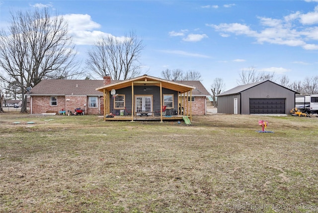 rear view of house featuring brick siding, a detached garage, an outdoor structure, french doors, and a chimney