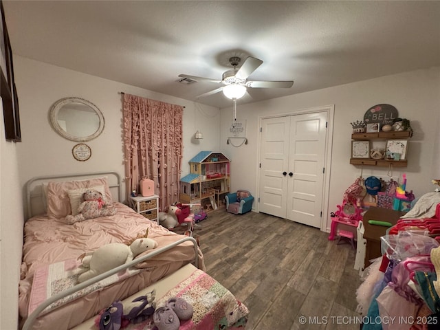 bedroom featuring visible vents, a closet, wood finished floors, and a ceiling fan