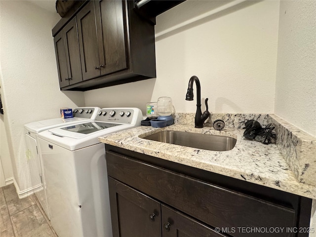 washroom featuring wood finished floors, separate washer and dryer, a sink, and cabinet space