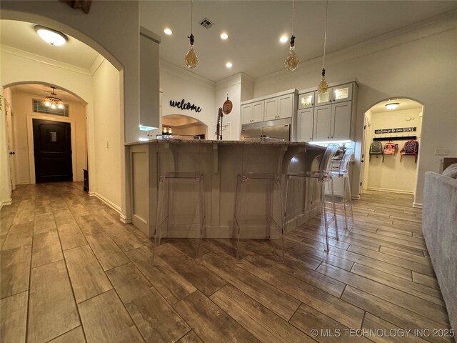 kitchen featuring arched walkways, visible vents, and wood tiled floor