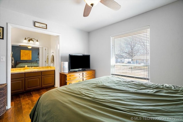 bedroom with dark wood-style floors, ensuite bath, and a ceiling fan