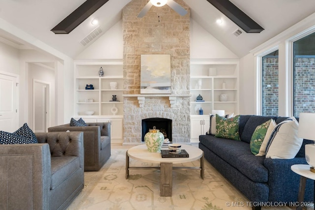 living room featuring beamed ceiling, a fireplace, visible vents, and built in features