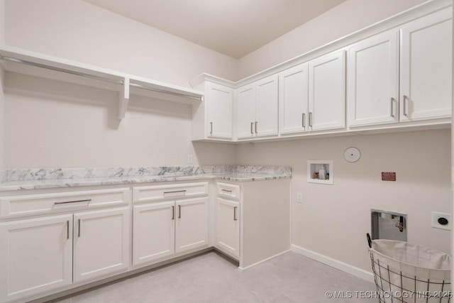 clothes washing area featuring washer hookup, cabinet space, hookup for an electric dryer, gas dryer hookup, and baseboards