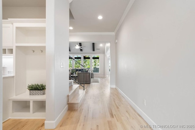 corridor featuring crown molding, recessed lighting, stairway, wood finished floors, and baseboards