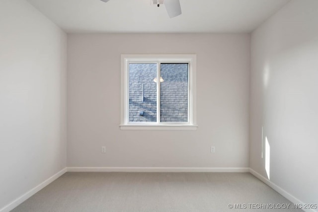 spare room with light colored carpet, ceiling fan, and baseboards