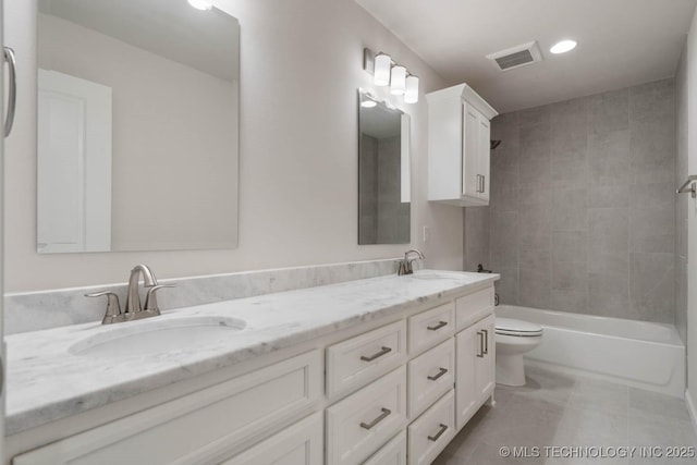 full bath featuring toilet, double vanity, a sink, and visible vents