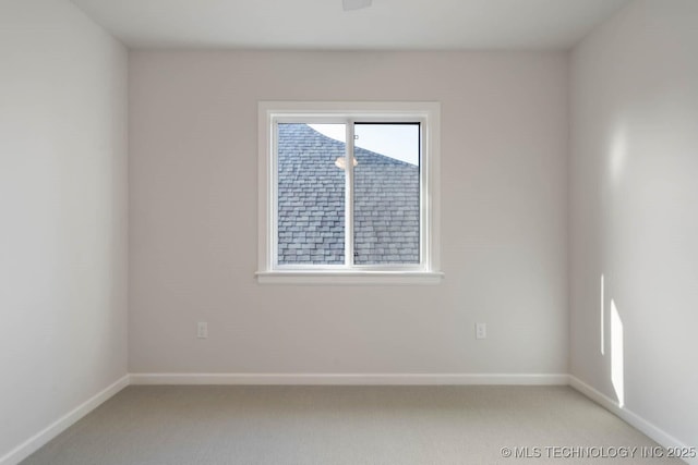 spare room with light colored carpet and baseboards