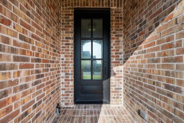 doorway to property featuring brick siding