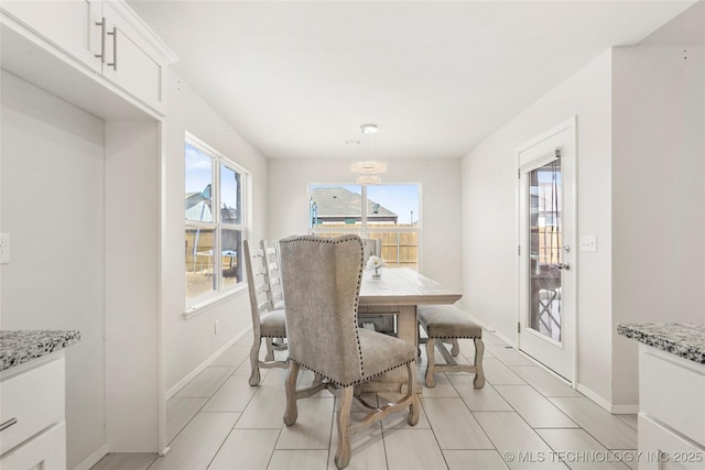 dining room with light tile patterned flooring and baseboards