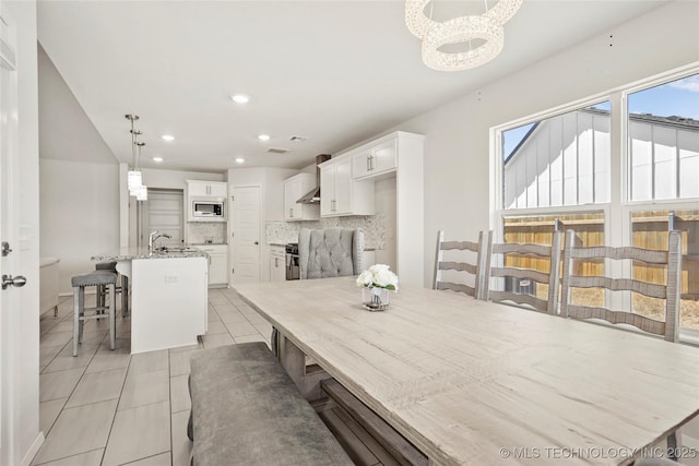 dining space with light tile patterned floors, a chandelier, and recessed lighting