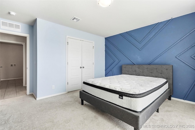 bedroom with a closet, visible vents, baseboards, and carpet flooring