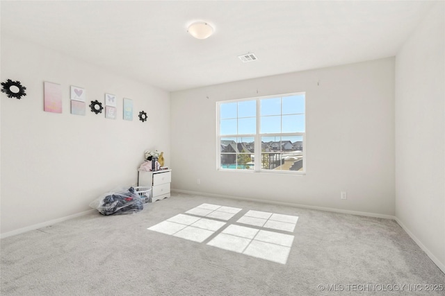 empty room featuring baseboards, visible vents, and carpet flooring