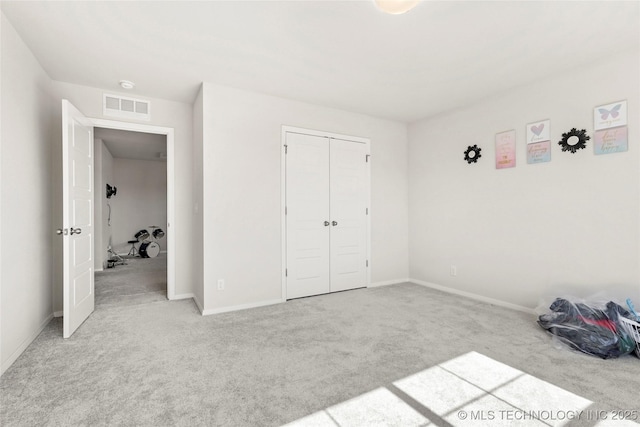 unfurnished bedroom with carpet floors, a closet, visible vents, and baseboards