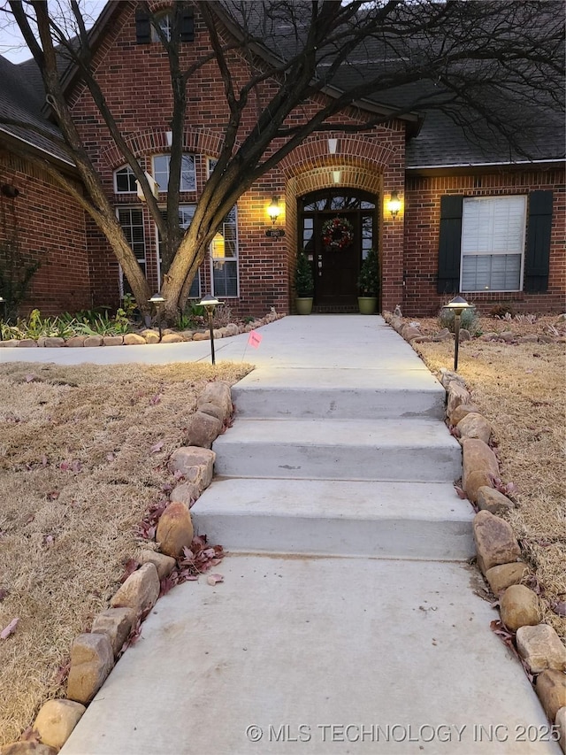 doorway to property featuring brick siding