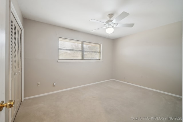 unfurnished bedroom with a ceiling fan, a closet, light carpet, and baseboards