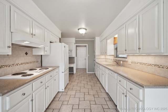 kitchen with under cabinet range hood, white appliances, a sink, white cabinets, and decorative backsplash