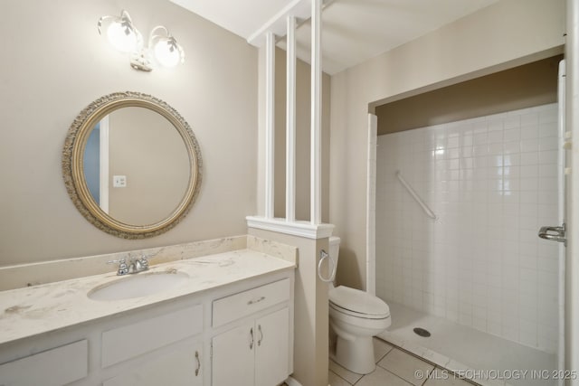 bathroom with vanity, a shower stall, toilet, and tile patterned floors