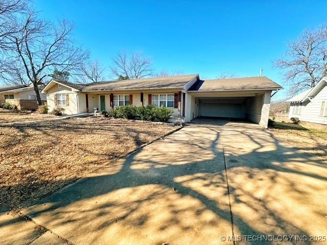 single story home with driveway and an attached carport