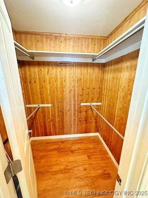 spacious closet featuring elevator and wood finished floors