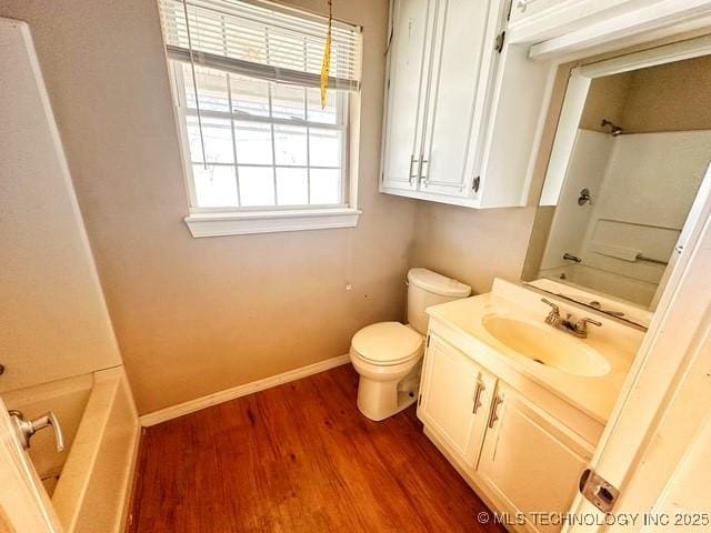 full bathroom with bathtub / shower combination, toilet, vanity, wood finished floors, and baseboards