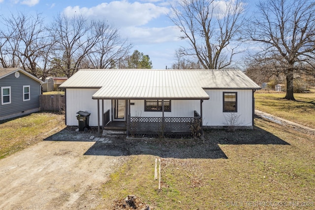 view of front of property featuring metal roof, a porch, and a front yard