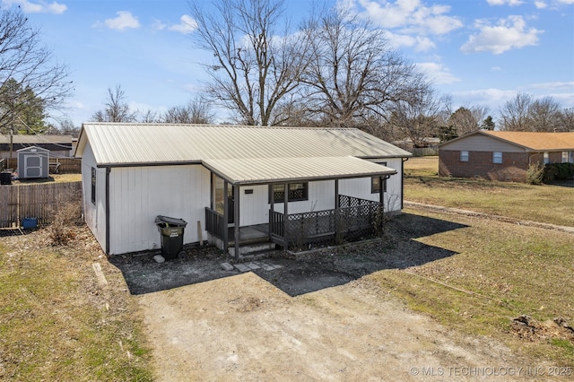 view of outdoor structure featuring covered porch and dirt driveway