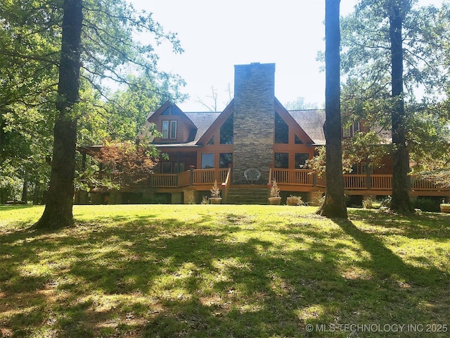 back of house with a yard, a chimney, and a wooden deck