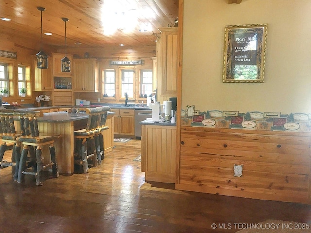 kitchen with light wood finished floors, light brown cabinetry, wood ceiling, dishwasher, and a kitchen bar