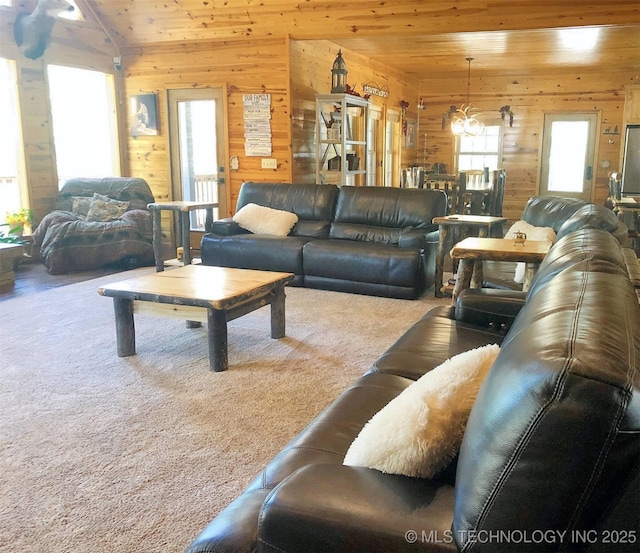 carpeted living room featuring wooden ceiling, wooden walls, and a chandelier