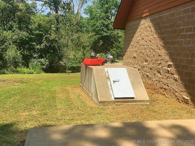 view of storm shelter with a yard