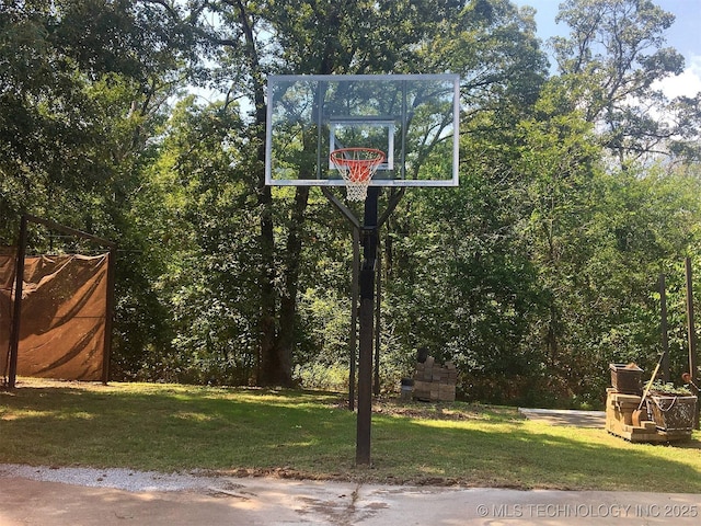 view of sport court with a lawn