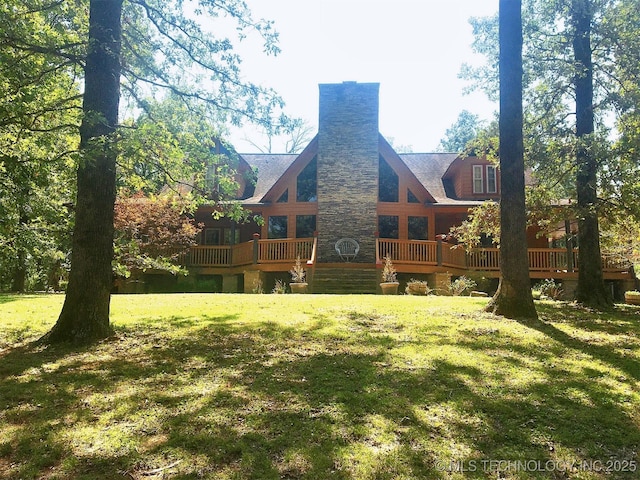 back of property with a deck and a lawn