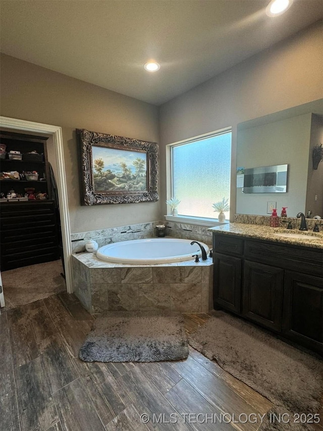 17 Tabernacle Dr, Calera, OK 74730 - bathroom featuring a spacious closet, vanity, a bath, and wood finished floors
