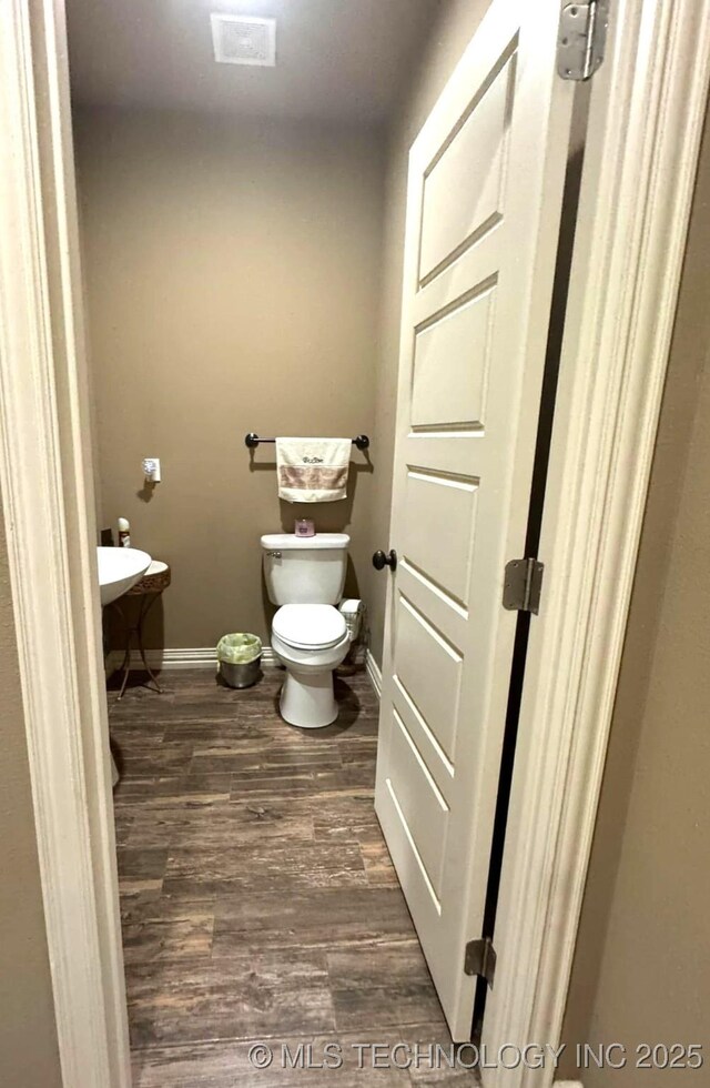 17 Tabernacle Dr, Calera, OK 74730 - bathroom featuring toilet, wood finished floors, and baseboards