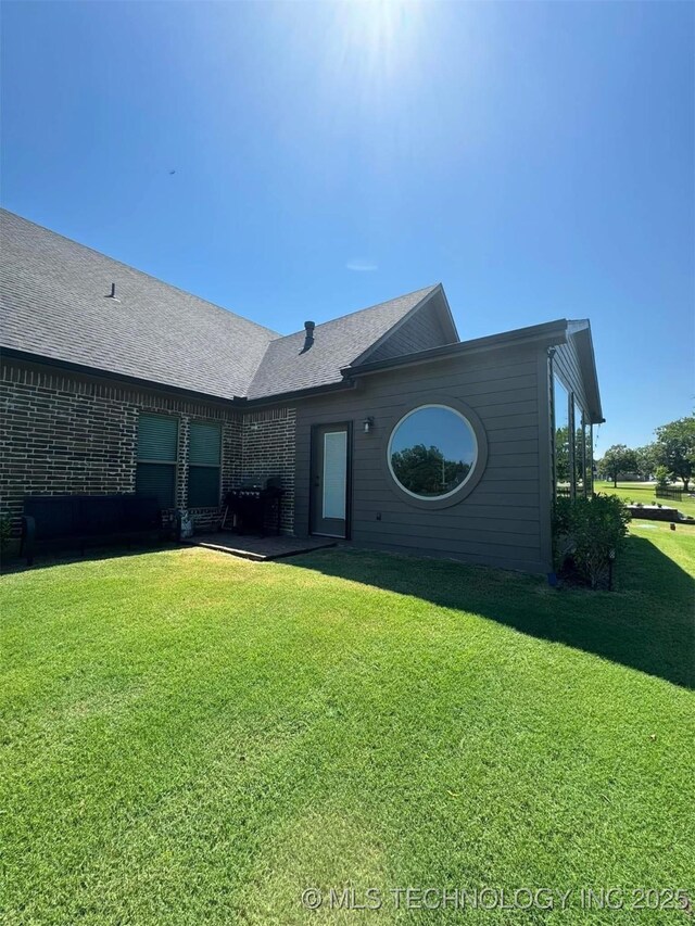 17 Tabernacle Dr, Calera, OK 74730 - rear view of property featuring a yard, a shingled roof, and brick siding
