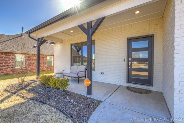 property entrance featuring brick siding and a patio area