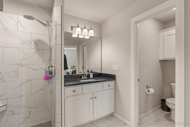 bathroom featuring toilet, marble finish floor, a shower stall, and baseboards