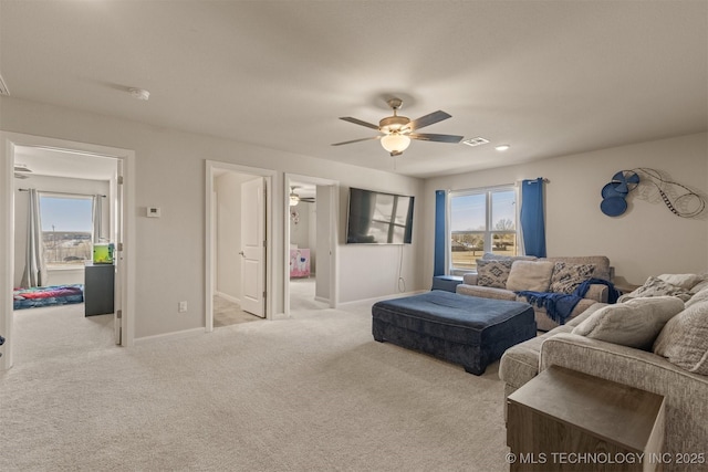 carpeted living room with a healthy amount of sunlight, baseboards, and visible vents