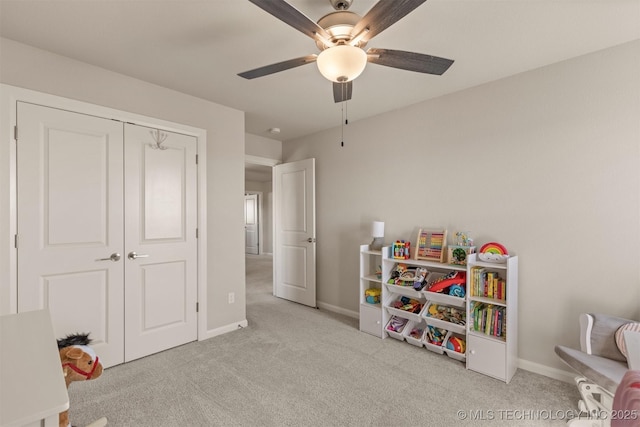 recreation room with carpet flooring, ceiling fan, and baseboards