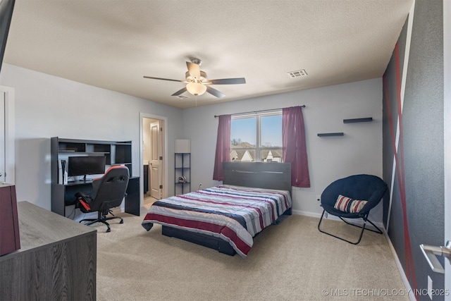 carpeted bedroom with a textured ceiling, ceiling fan, visible vents, and baseboards