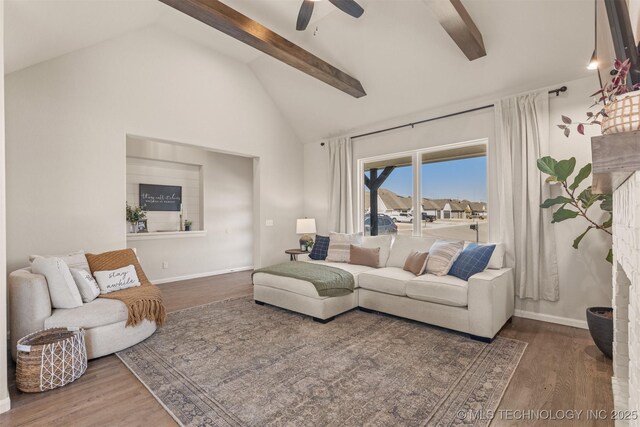 living room with beam ceiling, ceiling fan, baseboards, and wood finished floors