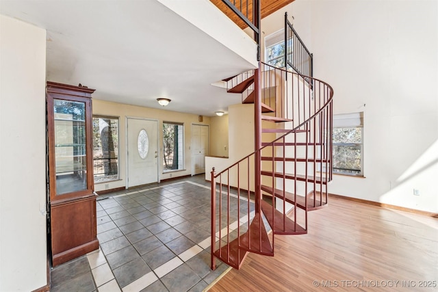 entrance foyer featuring stairs, baseboards, and wood finished floors